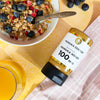 Manuka Doctor Manuka Honey 100 MGO with a bowl of cereal and honey on a checkered cloth.